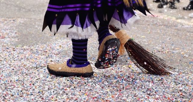 Parader dressed as a witch walking on confetti