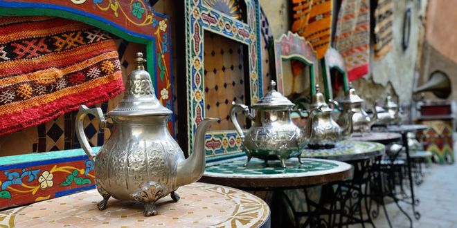 Tea jugs on painted tables at the market of the Rabat medina in Morocco