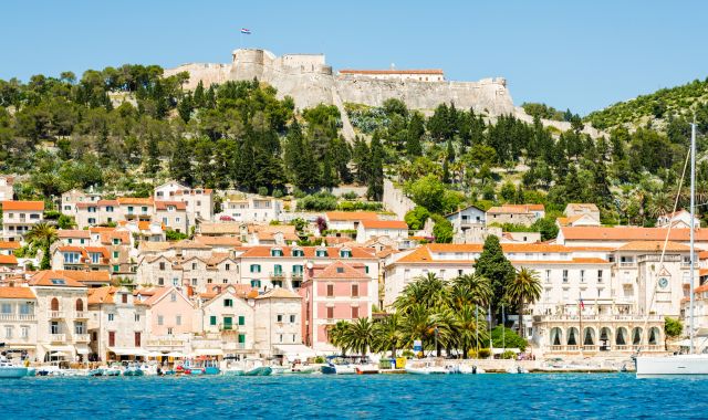 The city and castle of Hvar surrounded by greenery and water in Croatia