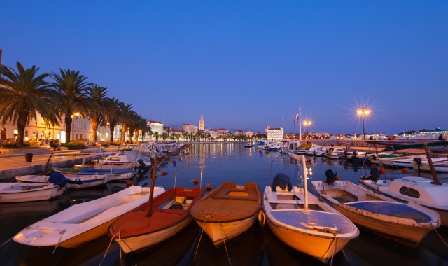 The ferry port of Split filled with boats at night in Croatia