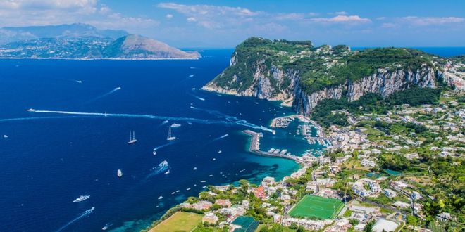 Aerial view of the coastline of Capri, Italy, with colorful houses and lush green hills